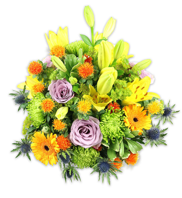 A richly hued, densely arranged bouquet sits crisply against a white background, its composition built from contrasts of warmth and coolness and from varied botanical textures. Dominant yellow Asiatic lilies form the vertical framework: some are fully open with speckled faces and visible stamens, others remain as poised, trumpet-shaped buds that add graceful height. Two or three powdery lavender-purple roses act as a soft, elegant focal point, their layered petals curling inward like small velvet shells. Large orange Gerbera daisies create immediate visual punctuation with flat, radiant petals surrounding darker centres, while clusters of lime-green button chrysanthemums supply substantial, cushion-like volume and a tactile, almost mossy feel. Intermittent bursts of small, spherical orange and golden round blooms - reminiscent of Craspedia or spiky accent flowers - introduce lively, tactile notes that invite a closer look. Several steel-blue sea thistles (Eryngium) project from the lower and lateral edges, their spiky, starry bracts offering a cool, architectural contrast that modernises the palette. Various greens - from broad lily foliage to slender stems and glossy filler leaves - weave through and frame the colours, enhancing depth and cohesion. Bathed in soft studio light, the bouquet feels celebratory yet refined, suitable as a warm anniversary gift, a sympathy tribute with uplifting tones, or a striking centrepiece for a weekend dinner. As a neighbourhood florist serving the Becontree Estate and visitors to Valence House, I select stems for freshness and balance so the arrangement will hold its shape and scent when placed on a mantel or café table.